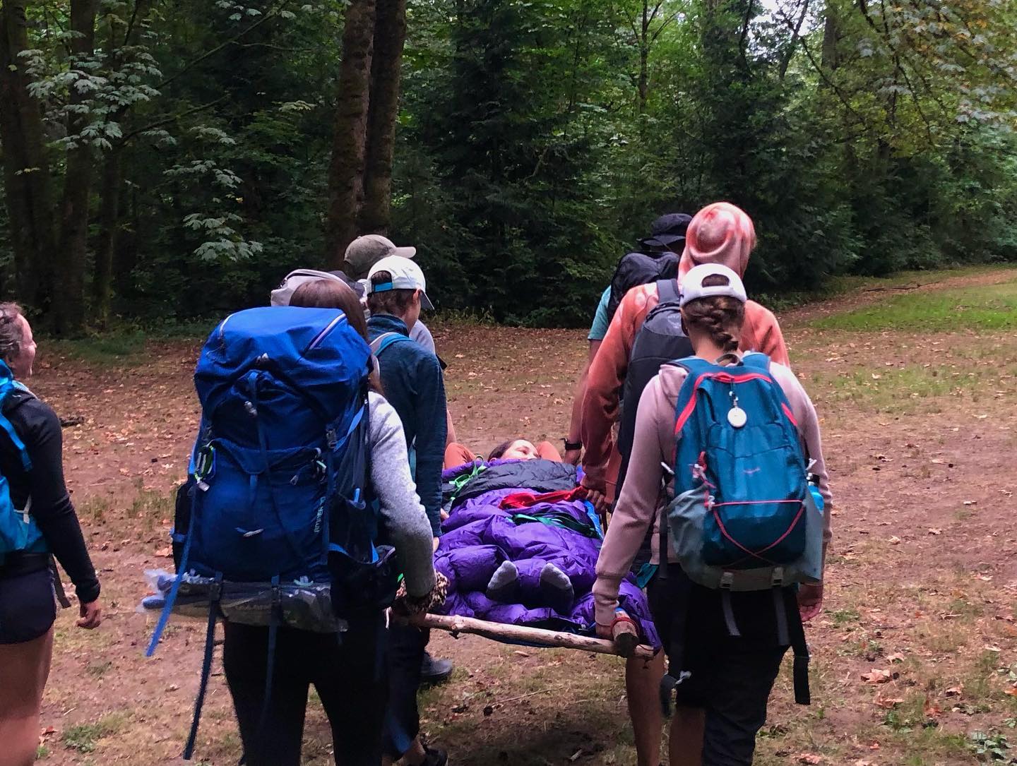 Group carrying patient out of remote area in Advanced Wilderness Certification training.