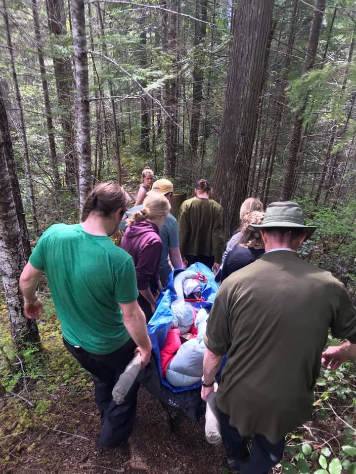 Wilderness First Aid Training, group carrying person to safety.
